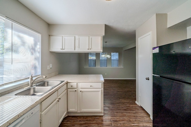 kitchen with white cabinetry, sink, hanging light fixtures, dark hardwood / wood-style floors, and white dishwasher