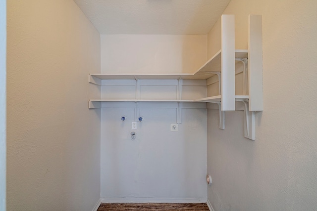 laundry area featuring washer hookup, a textured ceiling, dark wood-type flooring, electric dryer hookup, and hookup for a gas dryer