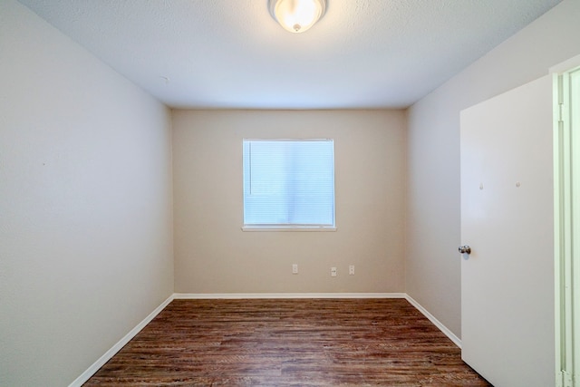 empty room with dark hardwood / wood-style flooring