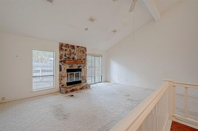 living room with high vaulted ceiling, a stone fireplace, carpet flooring, ceiling fan, and beam ceiling