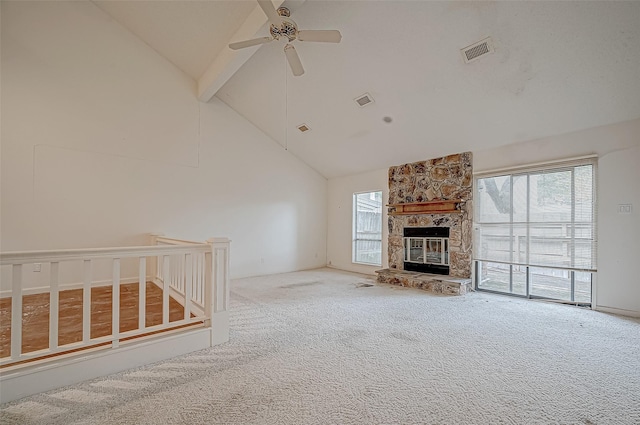 unfurnished living room featuring carpet, high vaulted ceiling, a stone fireplace, ceiling fan, and beamed ceiling