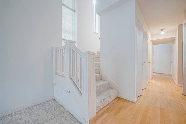 stairway featuring hardwood / wood-style floors and a textured ceiling