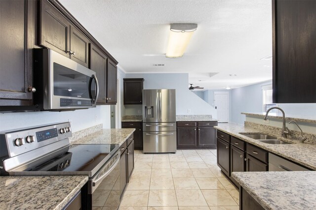 kitchen featuring ceiling fan, sink, stainless steel appliances, dark brown cabinets, and light tile patterned floors