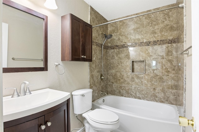 full bathroom with vanity, tiled shower / bath, and toilet