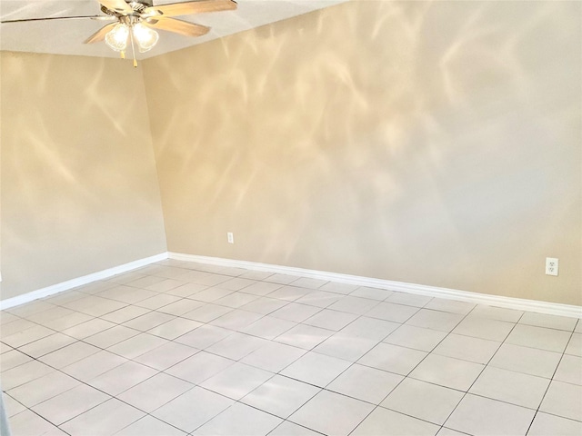 empty room with ceiling fan and light tile patterned flooring