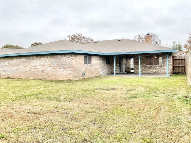 rear view of house featuring a patio area and a yard