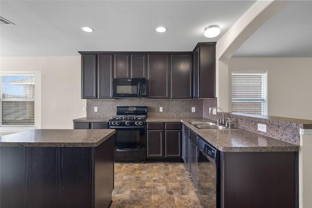 kitchen featuring sink, backsplash, a healthy amount of sunlight, and black appliances