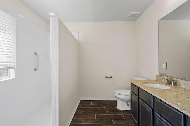 bathroom with walk in shower, hardwood / wood-style floors, vanity, and toilet