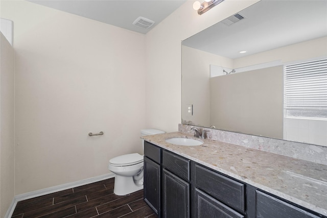 bathroom featuring wood-type flooring, vanity, and toilet