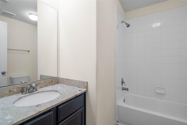 full bathroom with tiled shower / bath combo, toilet, and vanity