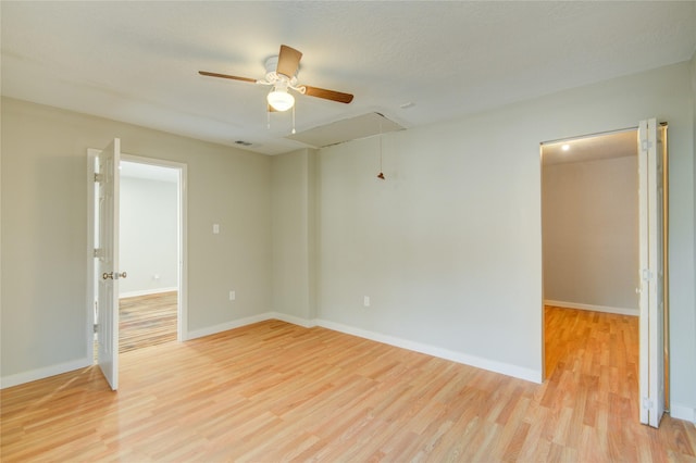 empty room with ceiling fan and light hardwood / wood-style flooring