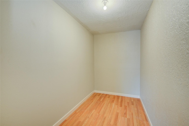 unfurnished room featuring hardwood / wood-style floors and a textured ceiling