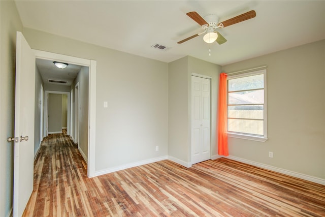 spare room with light wood-type flooring and ceiling fan