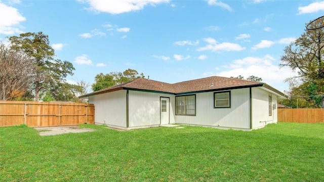 rear view of property featuring a lawn