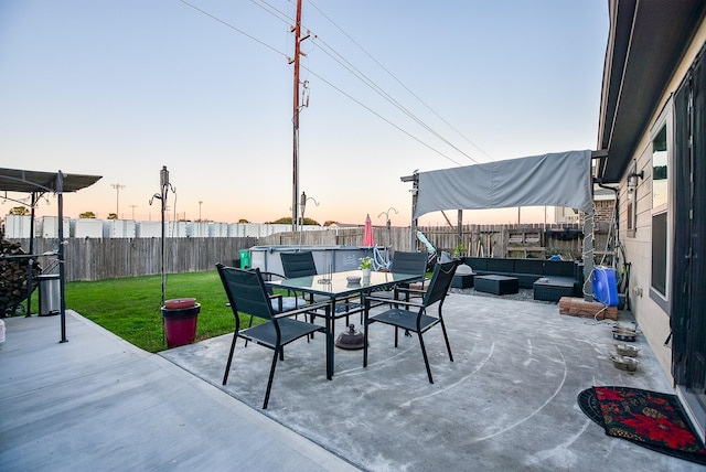 patio terrace at dusk with a yard and an outdoor hangout area