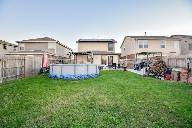 back of property featuring a lawn, a fenced in pool, and a patio