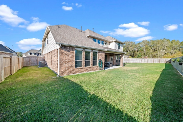 back of house featuring a shingled roof, a fenced backyard, a yard, central air condition unit, and brick siding