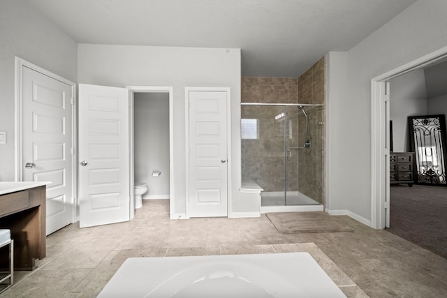 full bath with a stall shower, baseboards, vanity, and toilet