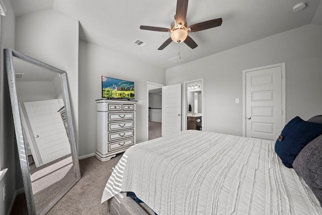 bedroom with dark colored carpet, lofted ceiling, visible vents, ensuite bathroom, and a ceiling fan