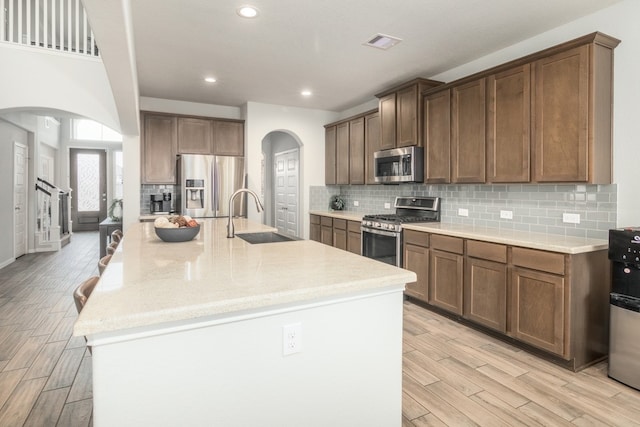 kitchen featuring appliances with stainless steel finishes, arched walkways, visible vents, and a sink