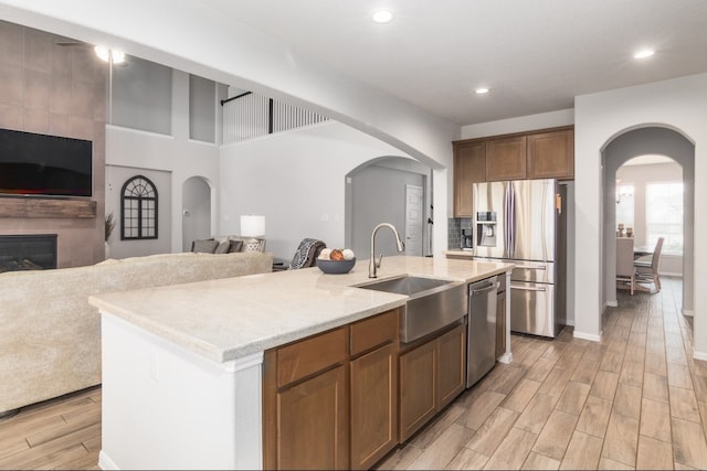 kitchen with appliances with stainless steel finishes, arched walkways, and a sink