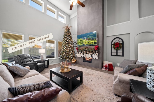 interior space with a ceiling fan, a fireplace, and a high ceiling