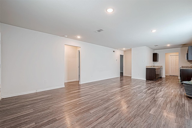 unfurnished living room with wood-type flooring and sink