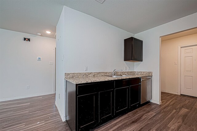 kitchen with dark hardwood / wood-style floors, stainless steel dishwasher, and sink