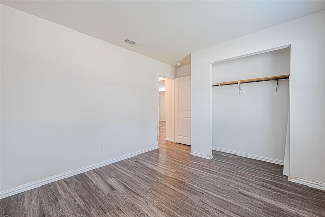 unfurnished bedroom featuring dark hardwood / wood-style flooring and a closet