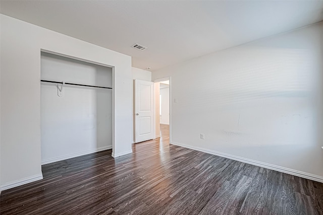 unfurnished bedroom with a closet and dark wood-type flooring