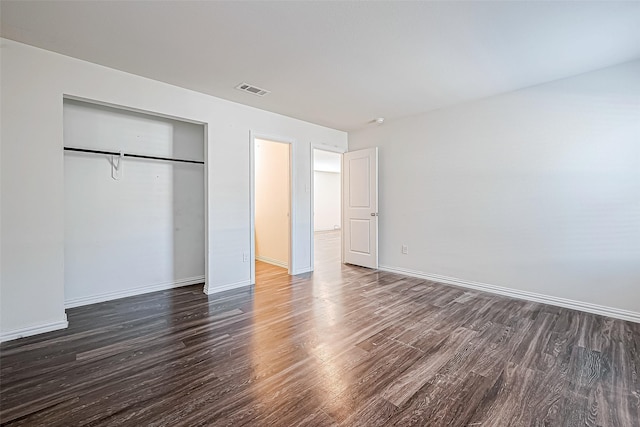 unfurnished bedroom featuring a closet and dark hardwood / wood-style floors