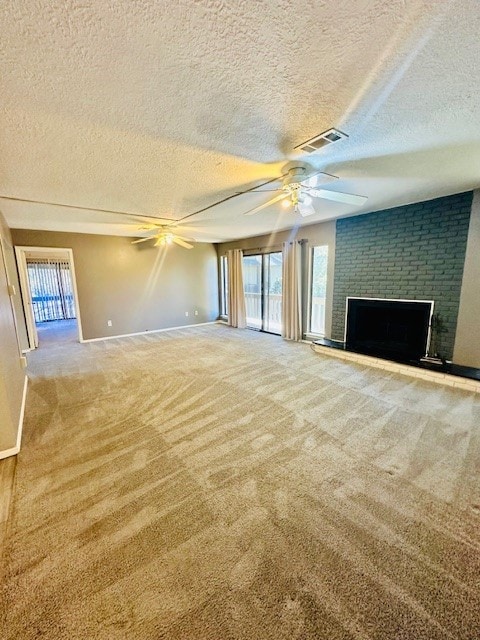 unfurnished living room featuring a textured ceiling, plenty of natural light, carpet floors, and a fireplace