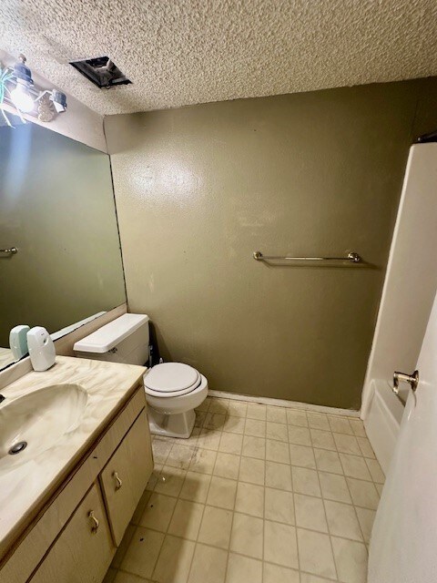 bathroom featuring tile patterned floors, vanity, and toilet