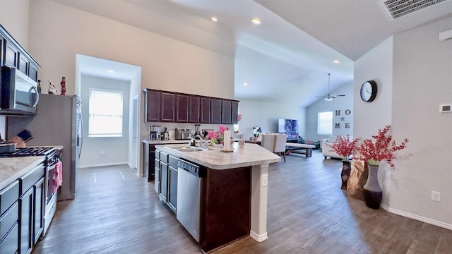 kitchen featuring ceiling fan, stainless steel appliances, a kitchen island with sink, and dark wood-type flooring