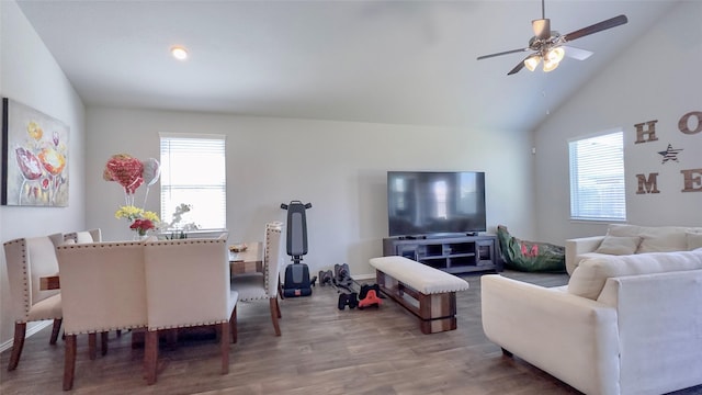 living room with hardwood / wood-style flooring, ceiling fan, and high vaulted ceiling