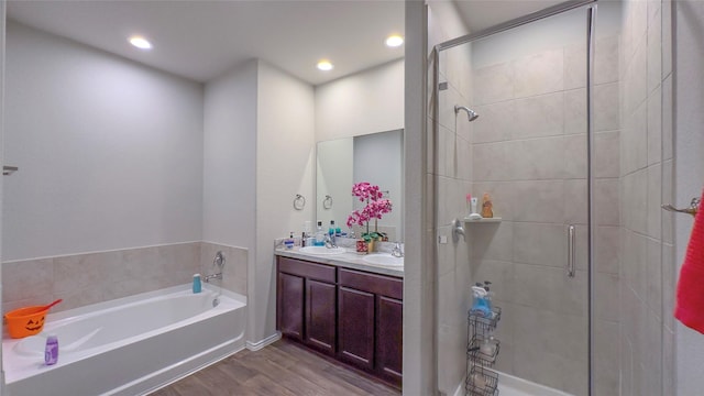 bathroom featuring independent shower and bath, vanity, and wood-type flooring