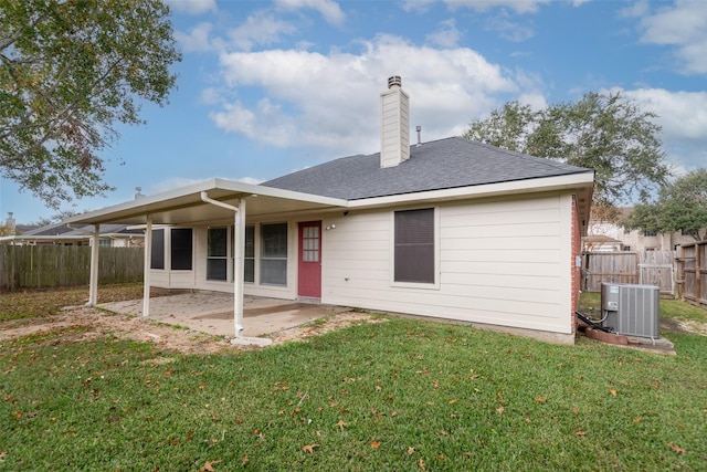 back of property with a lawn, a patio area, and central AC unit