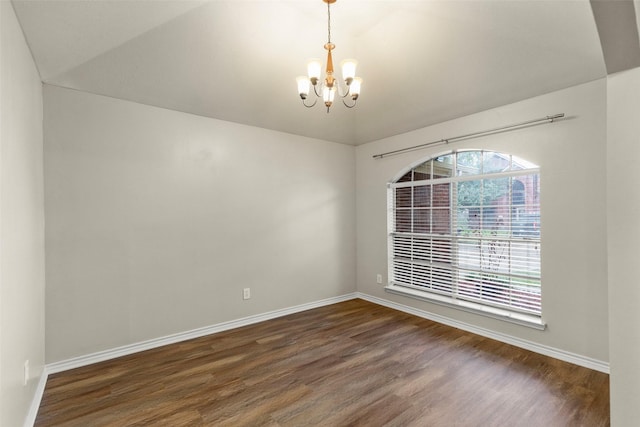 spare room with a notable chandelier, dark hardwood / wood-style floors, and lofted ceiling