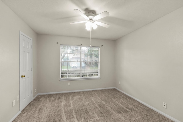 unfurnished room with ceiling fan and carpet