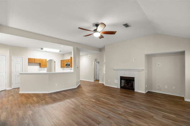 unfurnished living room with lofted ceiling, ceiling fan, a fireplace, and dark hardwood / wood-style floors