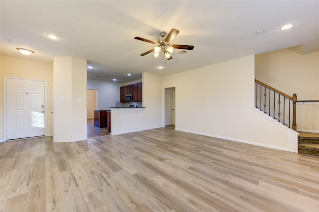 unfurnished living room featuring light wood-type flooring and ceiling fan