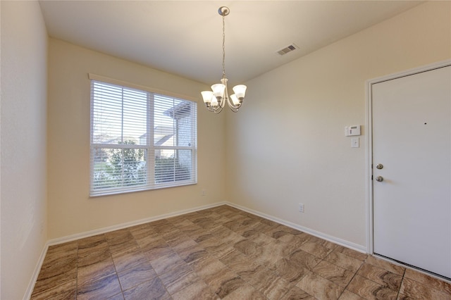 spare room featuring a chandelier