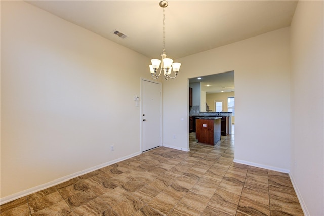 unfurnished dining area featuring a notable chandelier