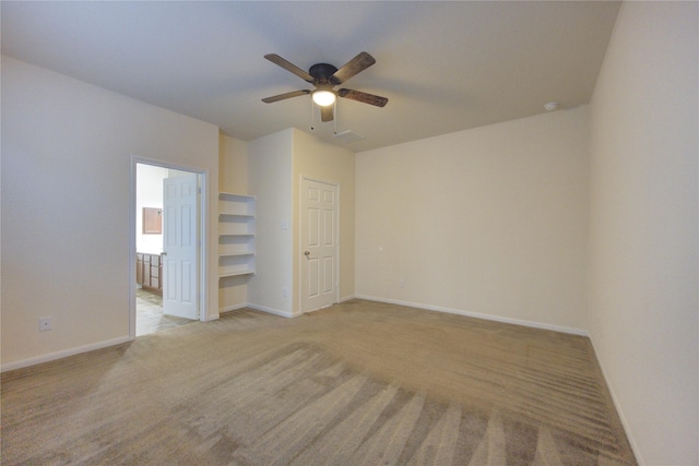 spare room with ceiling fan and light colored carpet