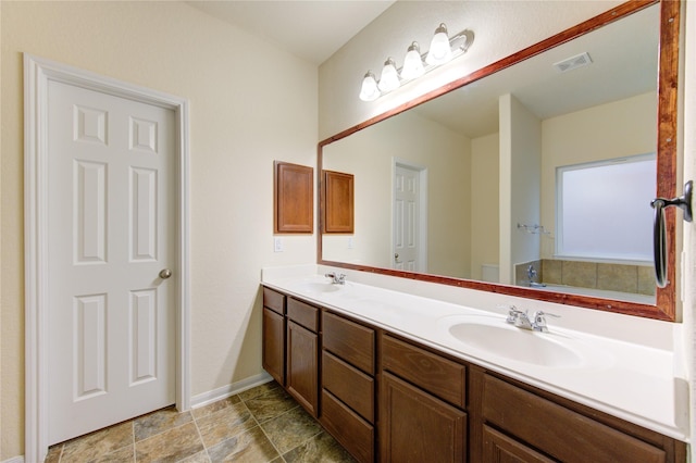 bathroom with a washtub and vanity