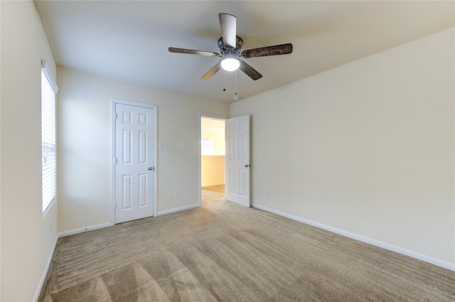 spare room with ceiling fan and light colored carpet