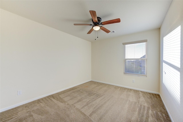 spare room featuring ceiling fan and light colored carpet