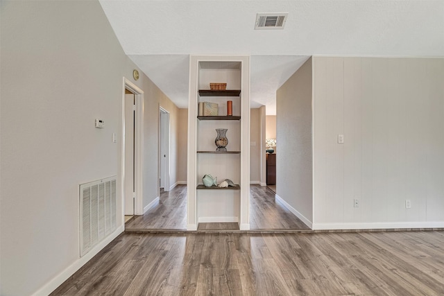 interior space featuring hardwood / wood-style floors and built in shelves