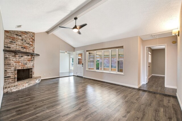 unfurnished living room featuring vaulted ceiling with beams, ceiling fan, a fireplace, a textured ceiling, and dark hardwood / wood-style flooring