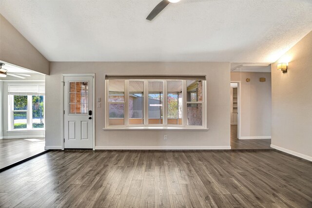 unfurnished living room featuring a textured ceiling, dark hardwood / wood-style floors, and ceiling fan